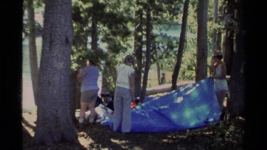 1978: some people are busy holding a big plastic to wrap something