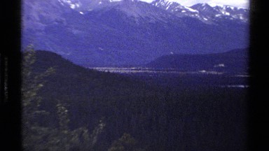 1979: Majestic Mountain Range and Lower Mountains Surround Flat Valley Under