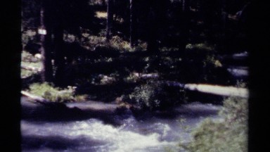 1979: a stream with a swift current runs through a hilly, forested area