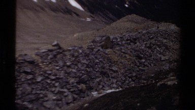 1979: piles of slag in a valley of tall rocks peaks and snow BRITISH COLUMBIA