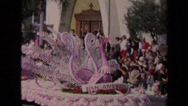 1967: crowds standing on the sideline watching a dove and princess float pass by