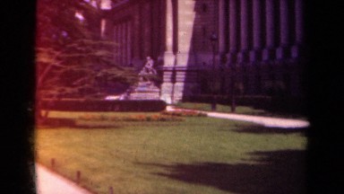 1939: a statue of a sitting man on a pedestal sits in front of a building PARIS