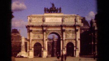 1939: people walk around in a plaza near an arch in a city PARIS FRANCE