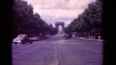 1939: vehicles on a road driving toward an entrance way PARIS FRANCE