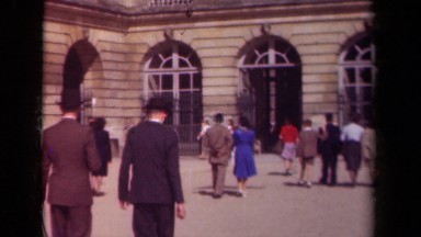 1939: Many People Walking Into a Building with Unique Architectural Details.