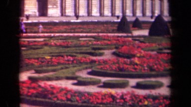 1939: A Group Strolling in the Background of a Lush Garden Maze, Paris France