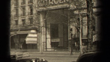1947: People Walking Past a Building as Cars Drive By Paris France