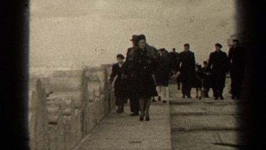 1947: a group of people walking through a town that is windy PARIS FRANCE