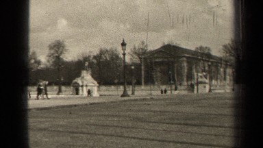 1947: people walk along a busy street near a large building PARIS FRANCE