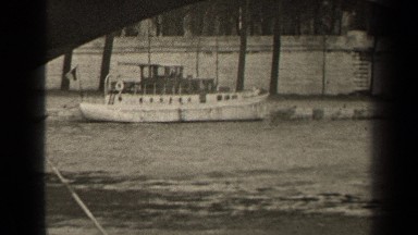 1947: a black and white video of a boat parked under a bridge. PARIS FRANCE