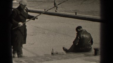 1947: a lady walks on the wall along the waterfront on a windy day PARIS FRANCE