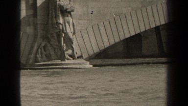 1947: bus crosses overpass toward city buildings while people and statues stand