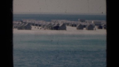 1947: Homes on Beach Near Flowing Blue Body of Water, PERSIAN GULF