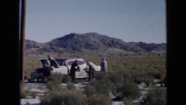 1952: group of men unload car, setting up card table in desert