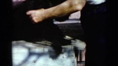 1953: man picks up dog and makes him stand up, holding his front legs CALIFORNIA