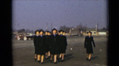 1947: women in uniform marching in formation, smiling as they approach camera