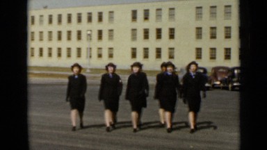 1947: new york women walking in synchronize parade on road and buildings