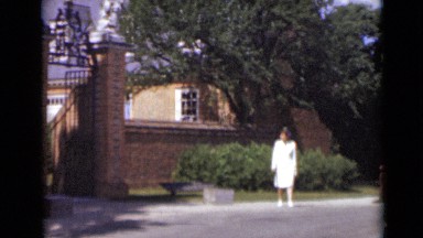 1947: nurse walking around compound wall and approaching entrance NEW YORK