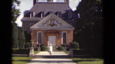 1947: woman posing in front of large house. NEW YORK
