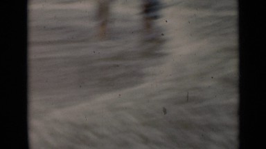 1947: two young women dip their feet into ocean and then walk beach NEW YORK