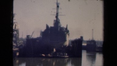 1946: ship being built at shipyard near large body of water in daytime.