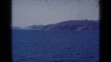 1947: shoreline with hills and cliffs as seen from out in water INDIA