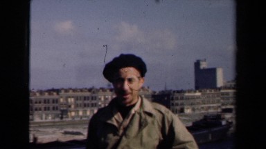 1946: handsome man wearing black cap is talking while standing in city