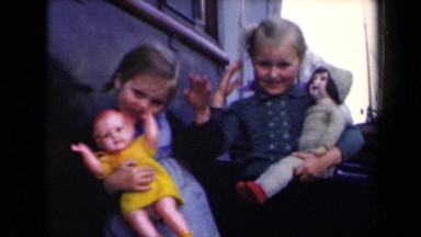 1946: two little kids are having toys and saying bye bye to someone