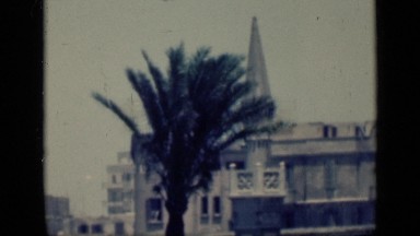 1946: two guys laughing and walking up to church on nice cloudy day. EGYPT