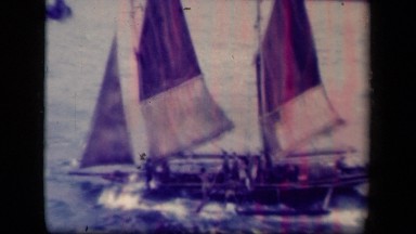 1944: lot of people standing on boat, sailing across wavy ocean enjoying breeze.
