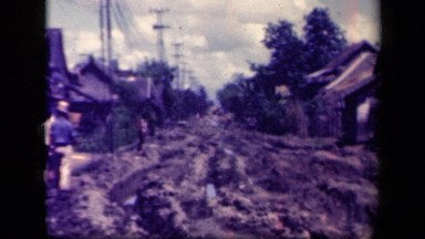 1944: road in neighborhood cover with what appears to be layers of dirt and mud