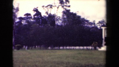 1944: White Stone Sign with Flag Flowing Over It in Papua New Guinea