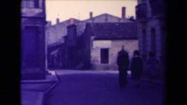 1945: three people walking down street alongside building's FRANCE