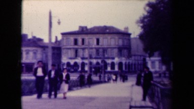 1945: people walking down road among many dwellings in town FRANCE