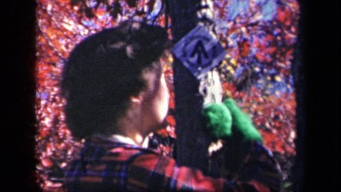1943: An Older Woman Standing Next to Tree Branch with Her Arm Around It