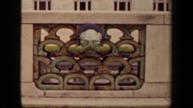1943: sculpted head of man on stone or cement fence in front of stone or cement