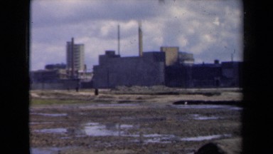 1946: Puddles of Water on Ground Against Industrial Factories