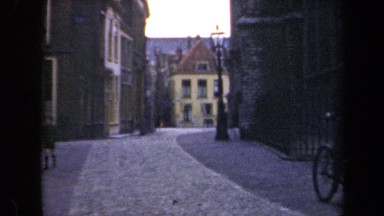 1946: man rides bicycle down street and passesmtwo children, boy and girl
