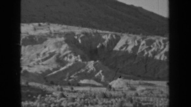 1937: panoramic view of mountainous, high desert landscape during daylight hours