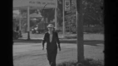 1937: woman crossing street walking towards camera BEND OREGON