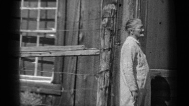 1937: grandmother watching her grandchildren run around flowering plant KLAMATH