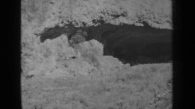 1937: person in distance walking along cave mountain KLAMATH CALIFORNIA