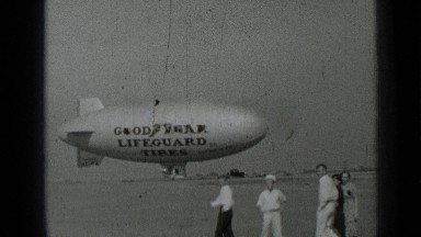 1937: lots of kids walking together with floating plane in background