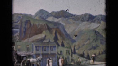 1937: man sits on buggy and travels along railroad surrounded by fake backdrop