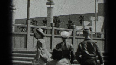 1937: people walking up staircase turn back and wave while american flag soars
