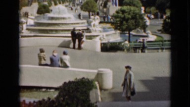 1937: woman turning walking down stairs in park, pointing towards something