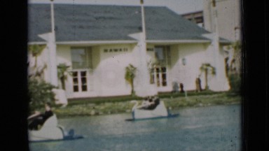 1937: people enjoying pedal boating in water body surrounded by garden