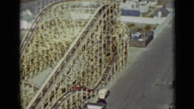 1937: attached cars ascend side of huge wooden roller coaster structure