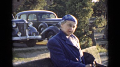 1939: an old lady standing in front of parked old fashioned cars ARIZONA