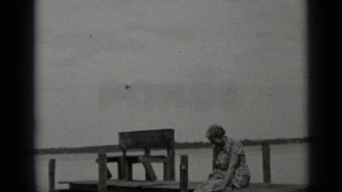 1939: the woman was sitting on bench and children were playing CLEAR LAKE